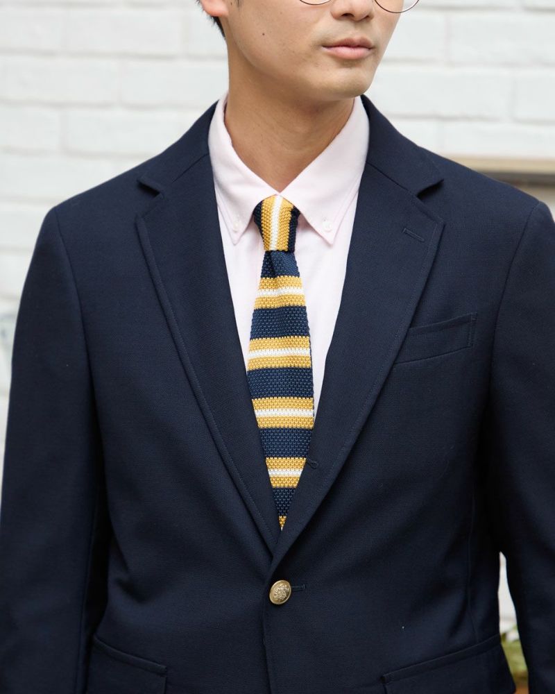 金ボタンと段返りラペルのディテール